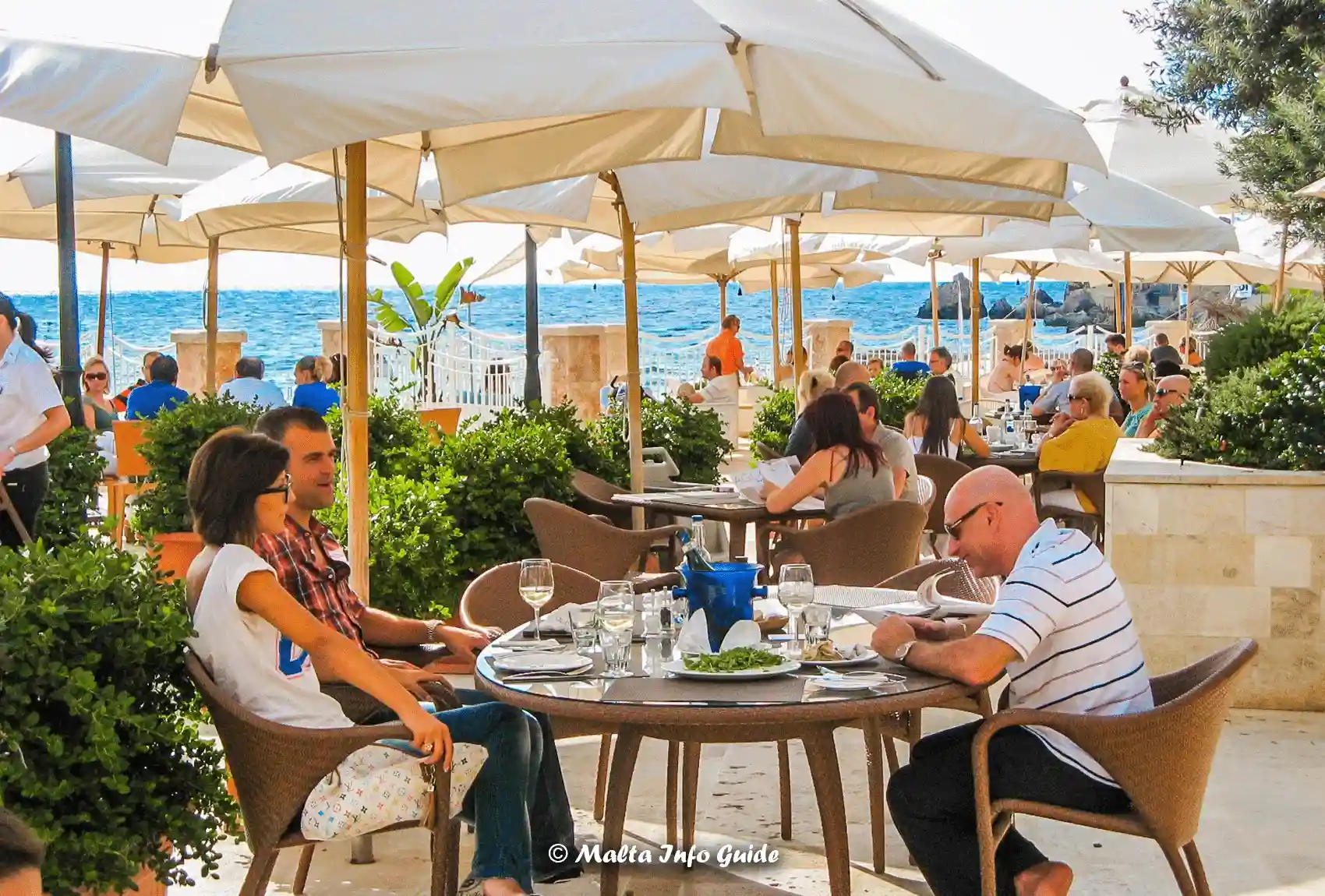 Guests dining outdoors at Agliolio beside Golden Bay.