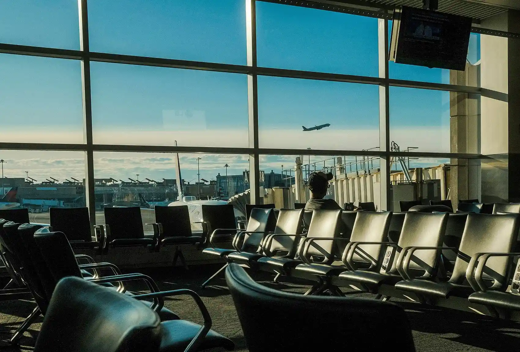 Airport departure lounge overlooking passenger planes and a departing aircraft.