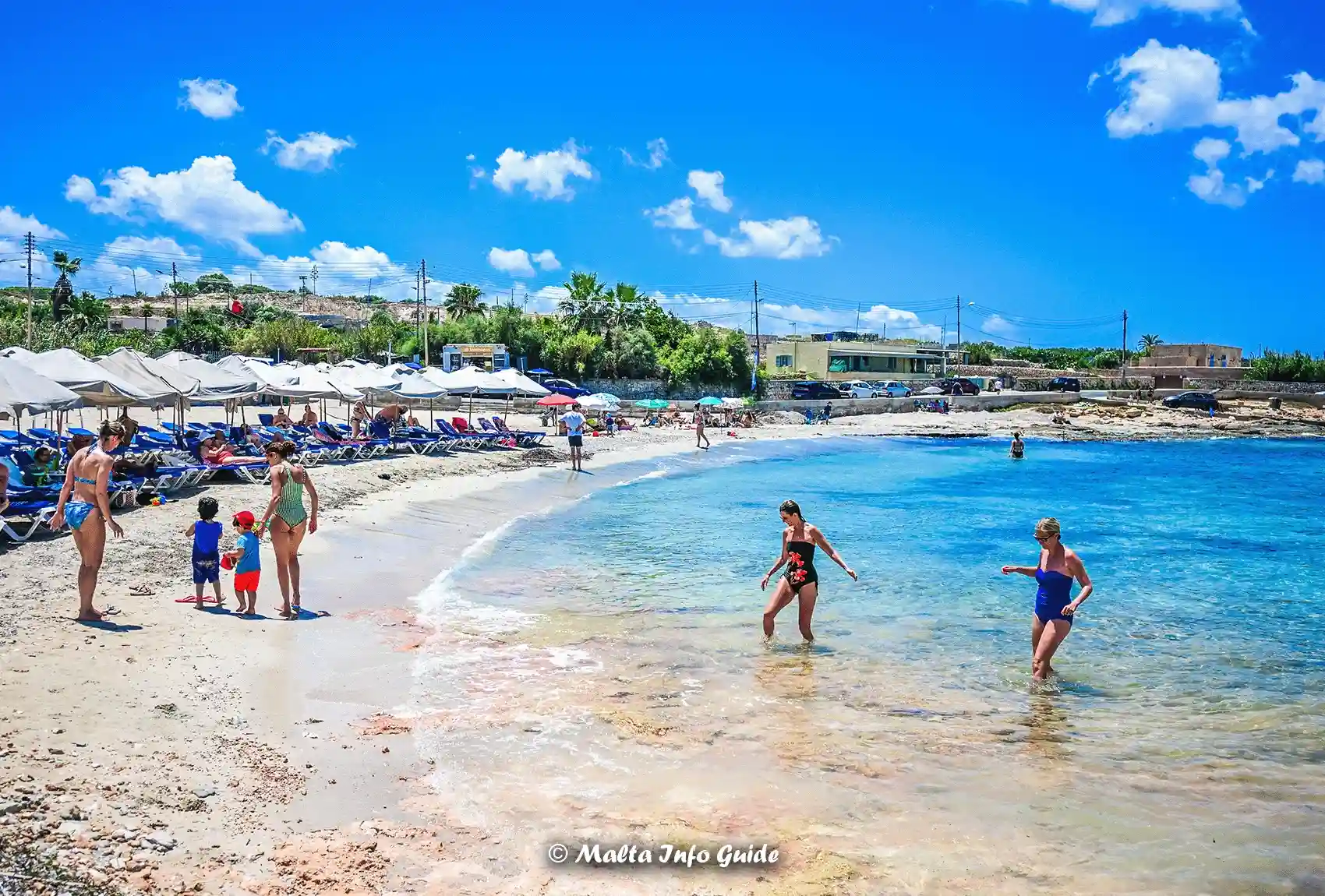 Visitors swimming beside the sandy shore at Armier Bay.