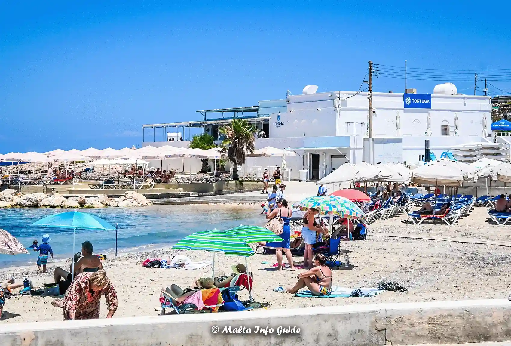 Tortuga Beach Club beside the sandy Little Armier shore.
