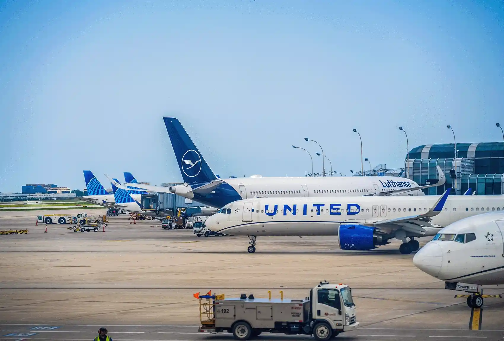 Passenger aircraft parked beside terminals at a busy airport.