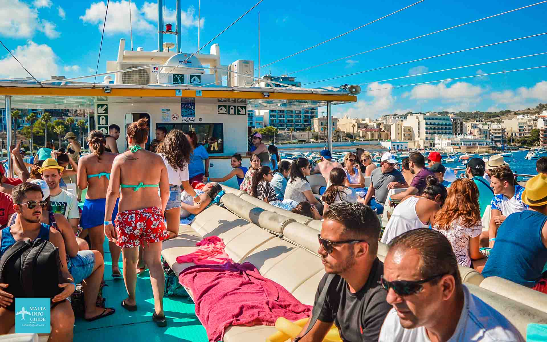 Pasajeros sentados en la cubierta superior del catamarán camino a Blue Lagoon Comino.