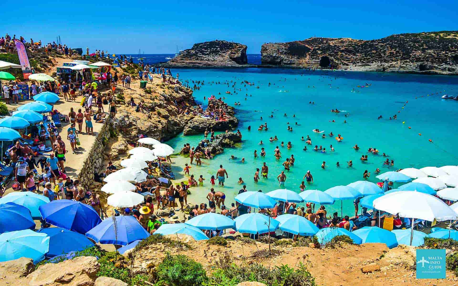 People sunbathing and swimming in the sea at Blue Lagoon Malta.