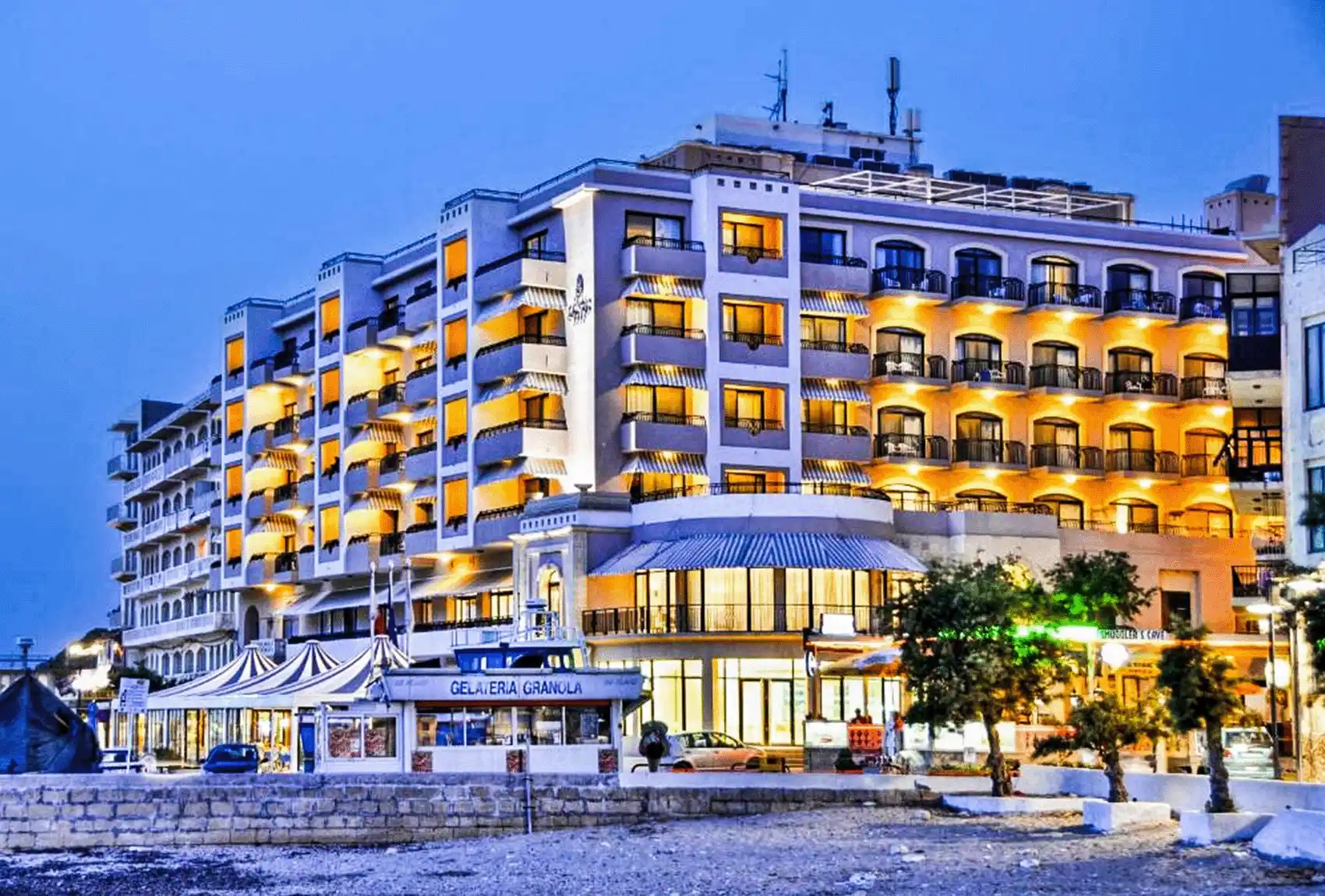 A view of the seafront of the Hotel Calypso in Marsalforn Bay, Gozo, Malta, at sunset.