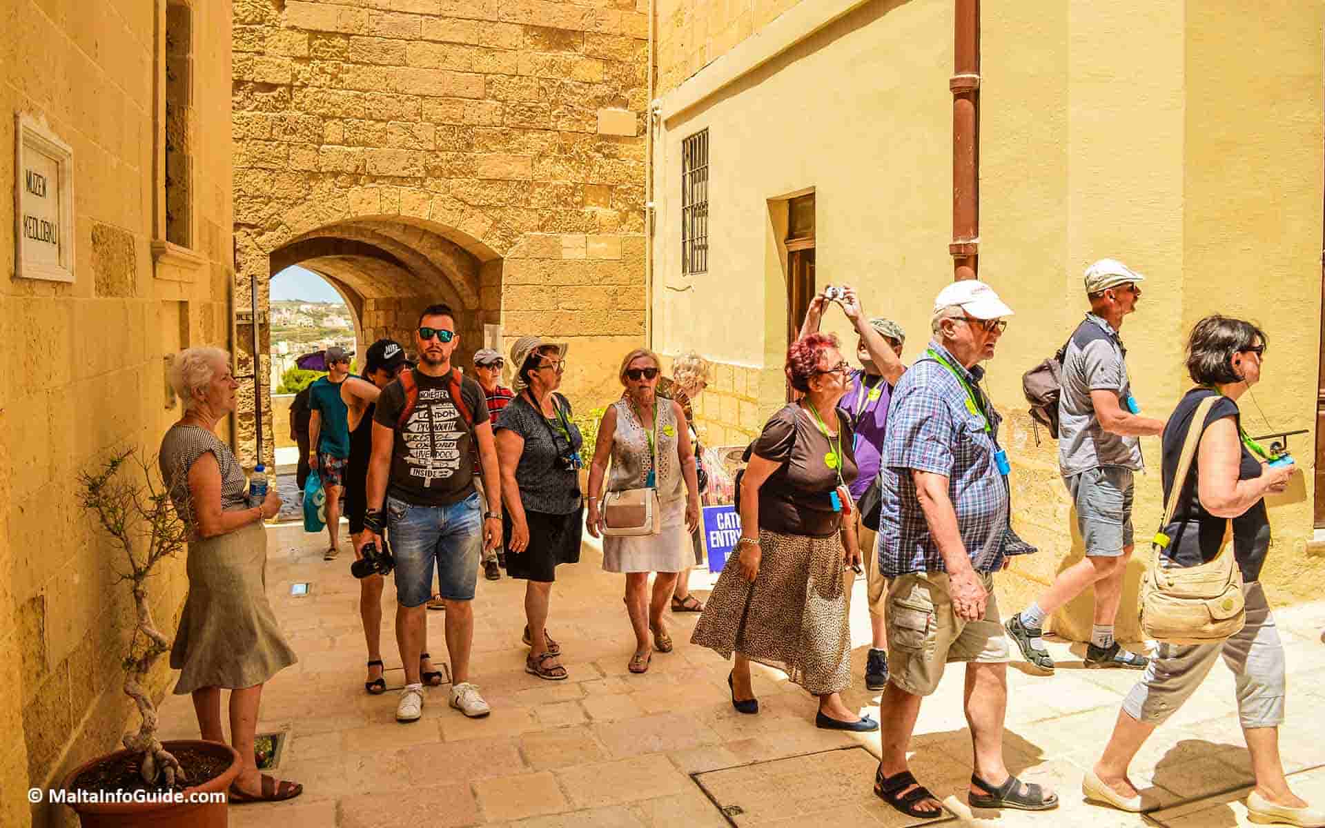 Tourists walking through the citadel narrow streets.