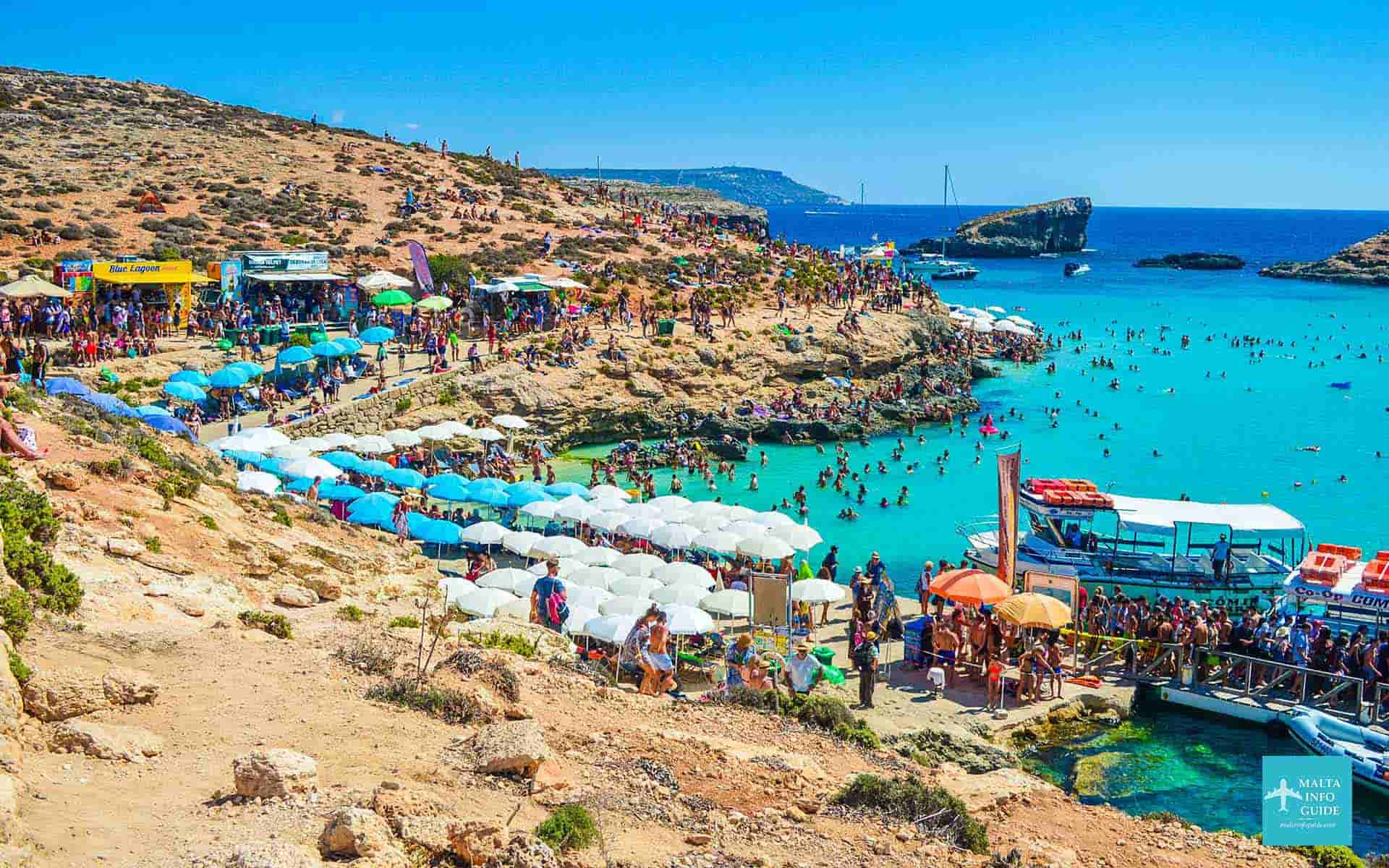 Blue Lagoon Malta is full of people swimming in the crystal clear sea.