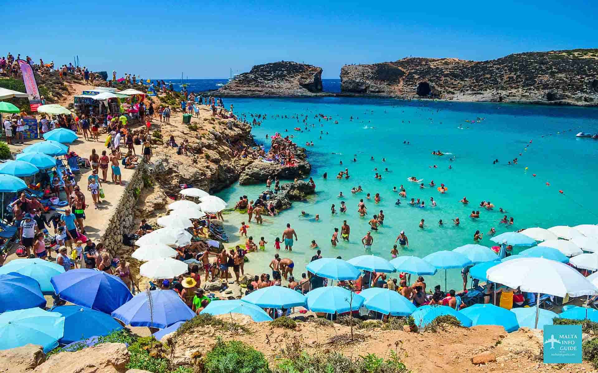 Comino island and Blue Lagoon Malta crowded with people swimming in the crystal blue sea.