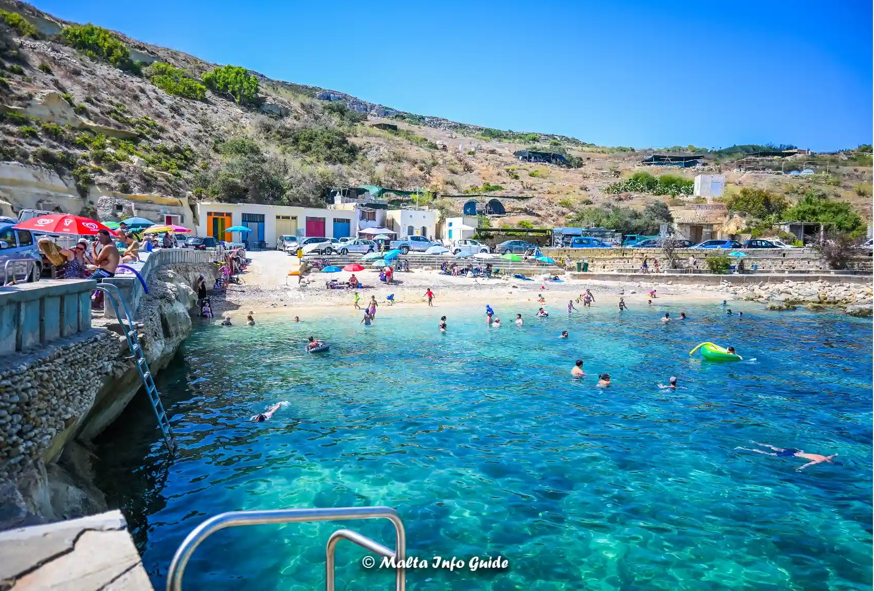 Swimmers in clear water at Dahlet Qorrot Bay.