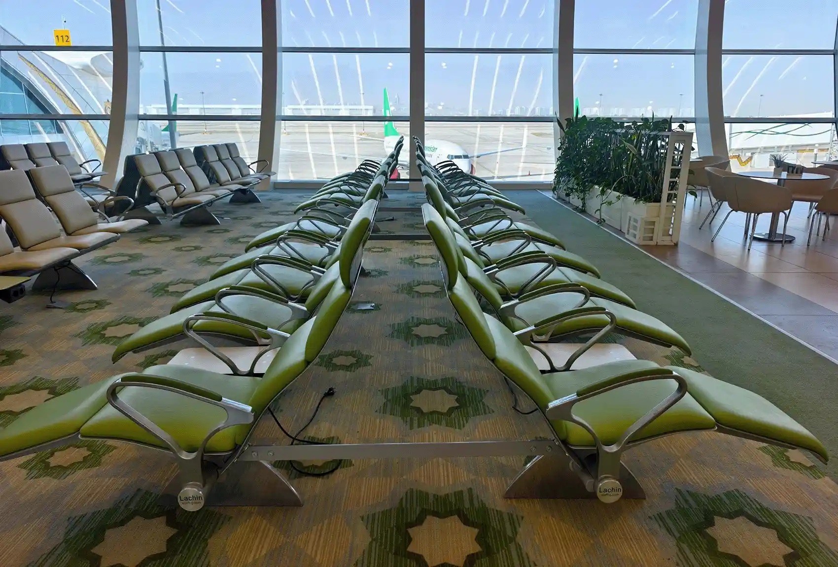 Airport departure gate with passenger seating and aircraft outside