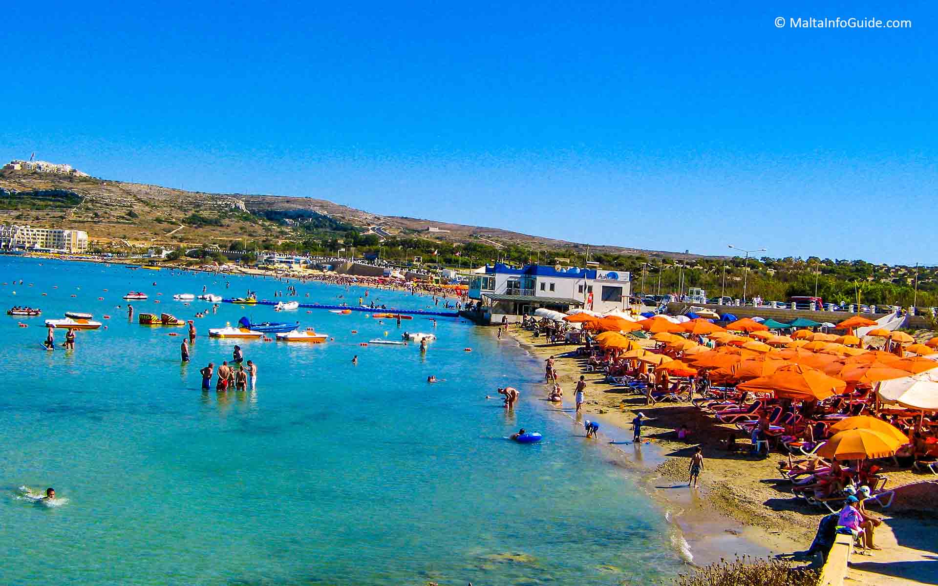 People flock to the beach of Mellieha Bay Malta.