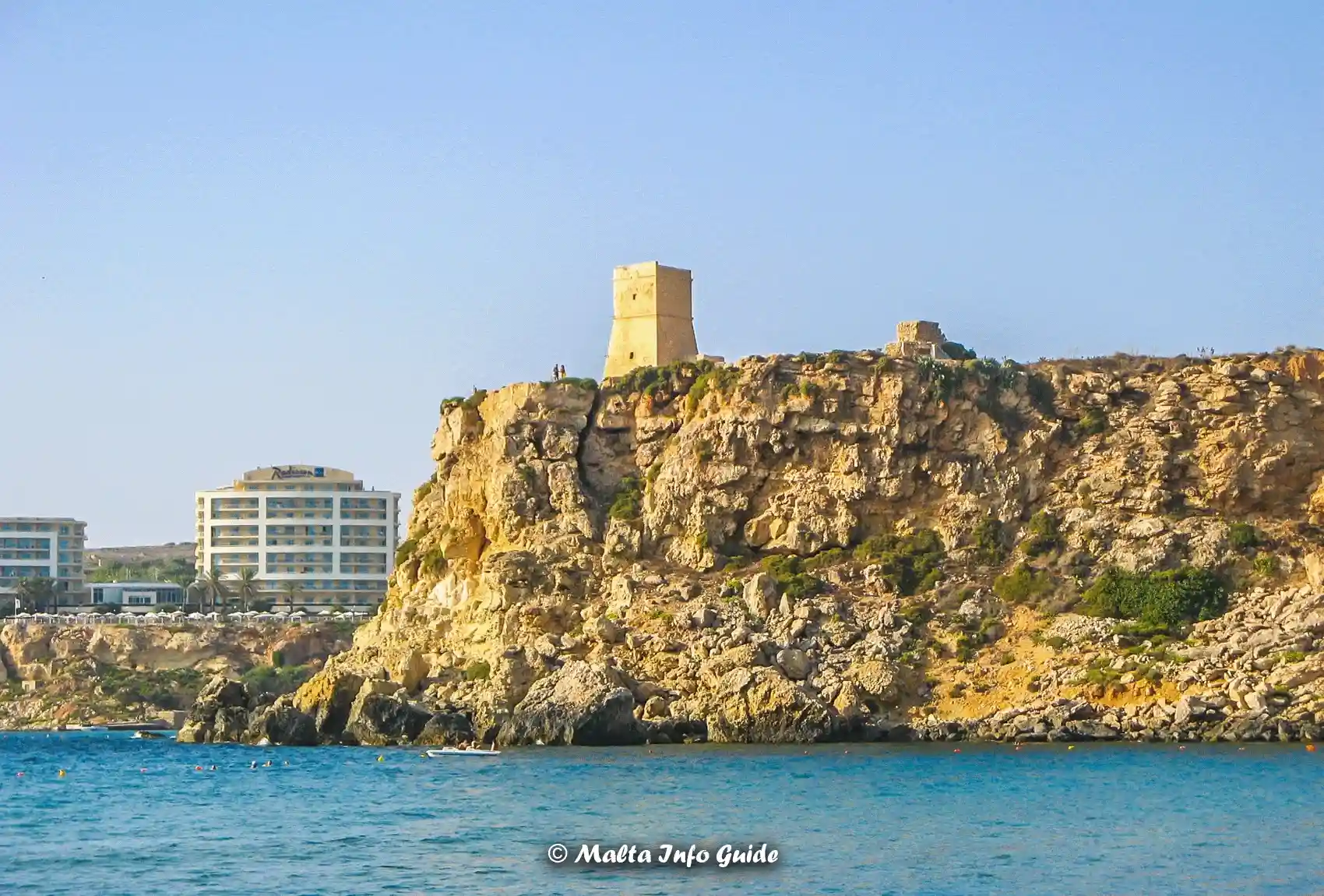 Għajn Tuffieħa Tower standing above rugged coastal cliffs.