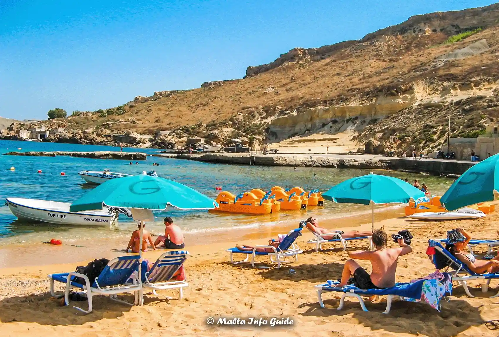 Sunbeds, umbrellas and pedal boats at Gnejna Bay.