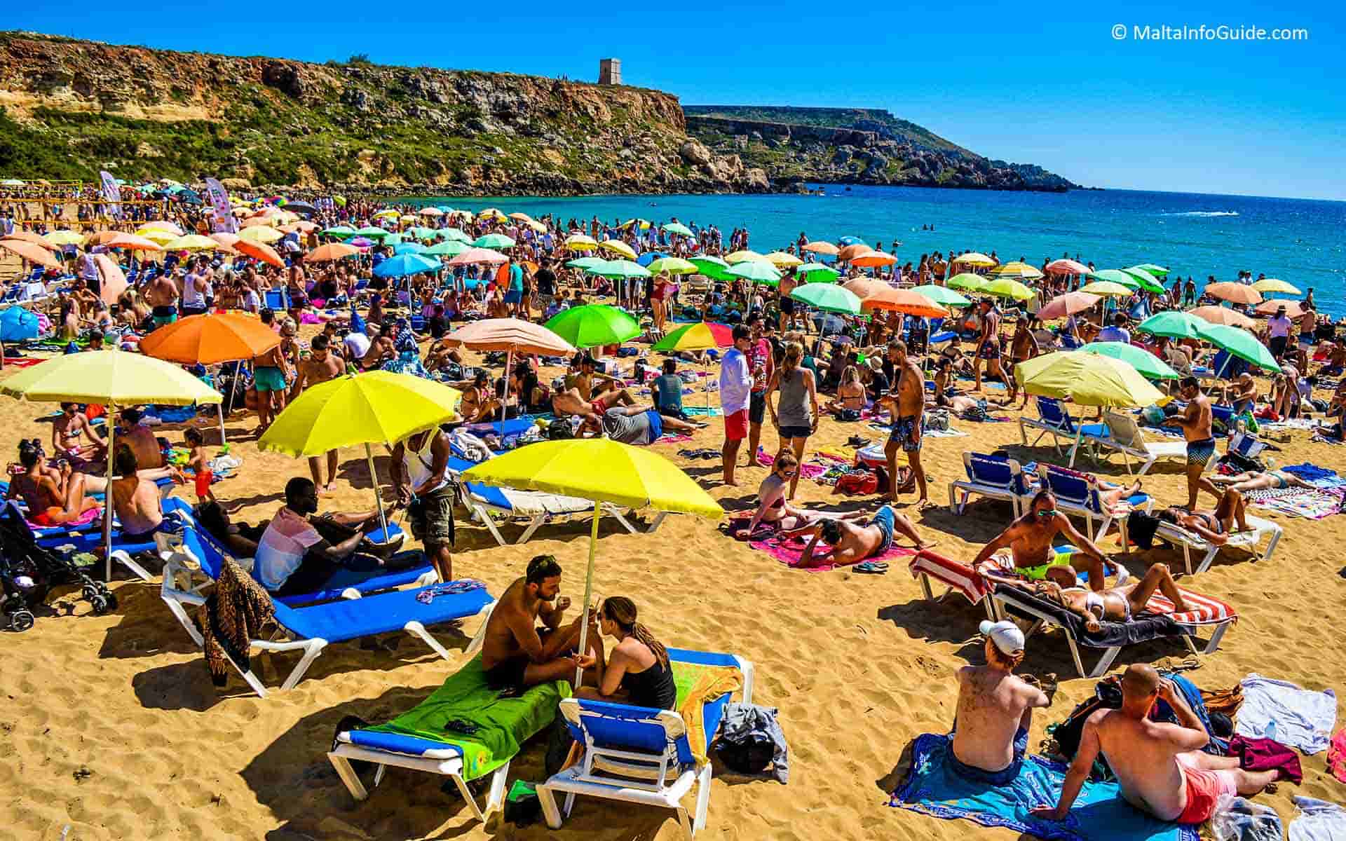 People on sunbeds at on of the best beaches, Golden Bay Malta
