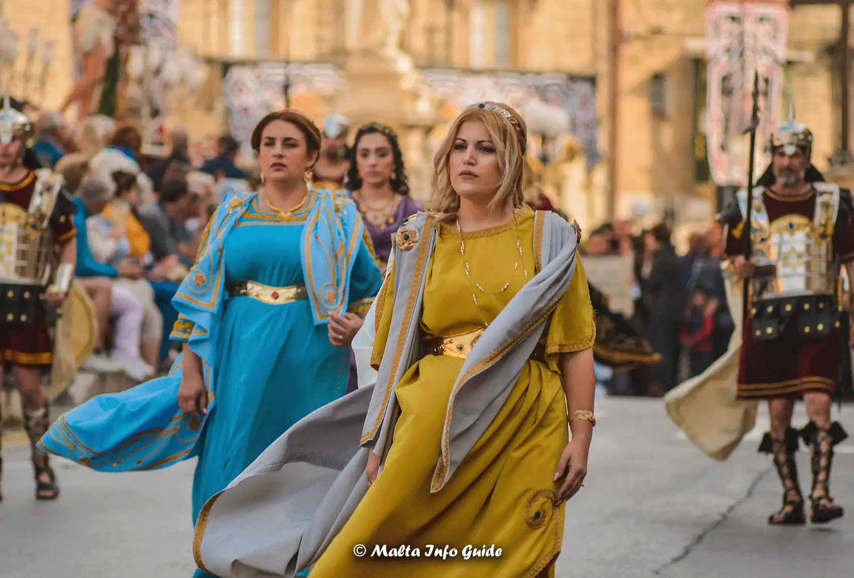 Women dressed up with costumes resembling people from Jesus's time during the Good Friday Procession in Zejtun. People walking through Zejtun for the Good Friday Procession.