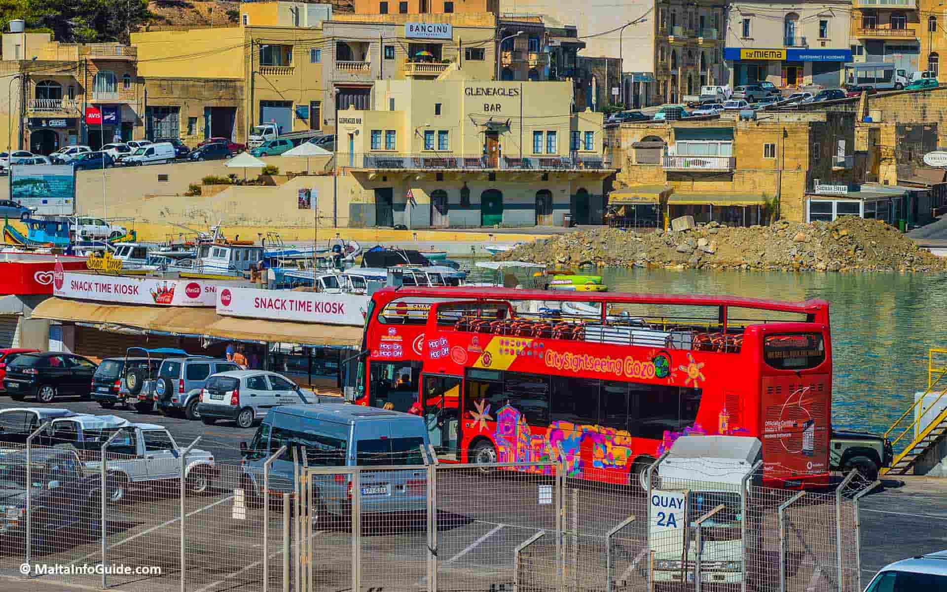 Two sightseeing buses at the Gozo ferry terminal in Mgarr. The very busy Mgarr harbour due to the continuous ferry connections with Malta.