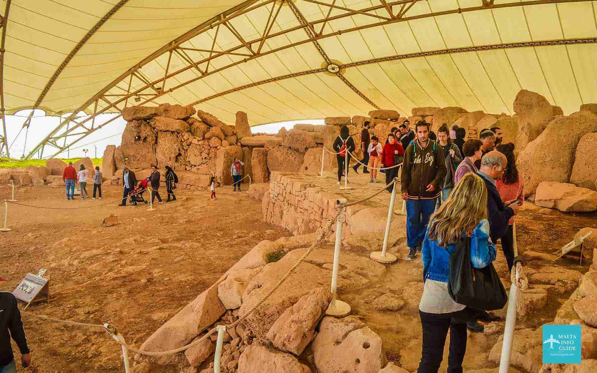 People walking around the Mnajdra temples.