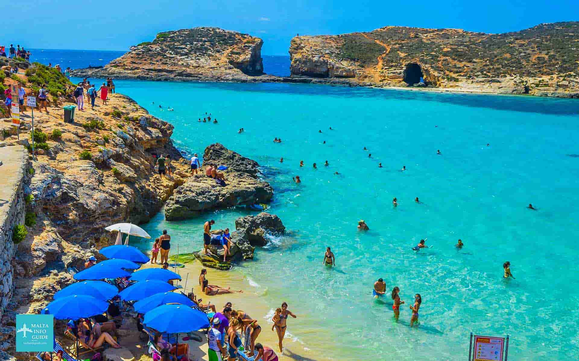 People swimming in the crystal sea at the Blue Lagoon Malta.