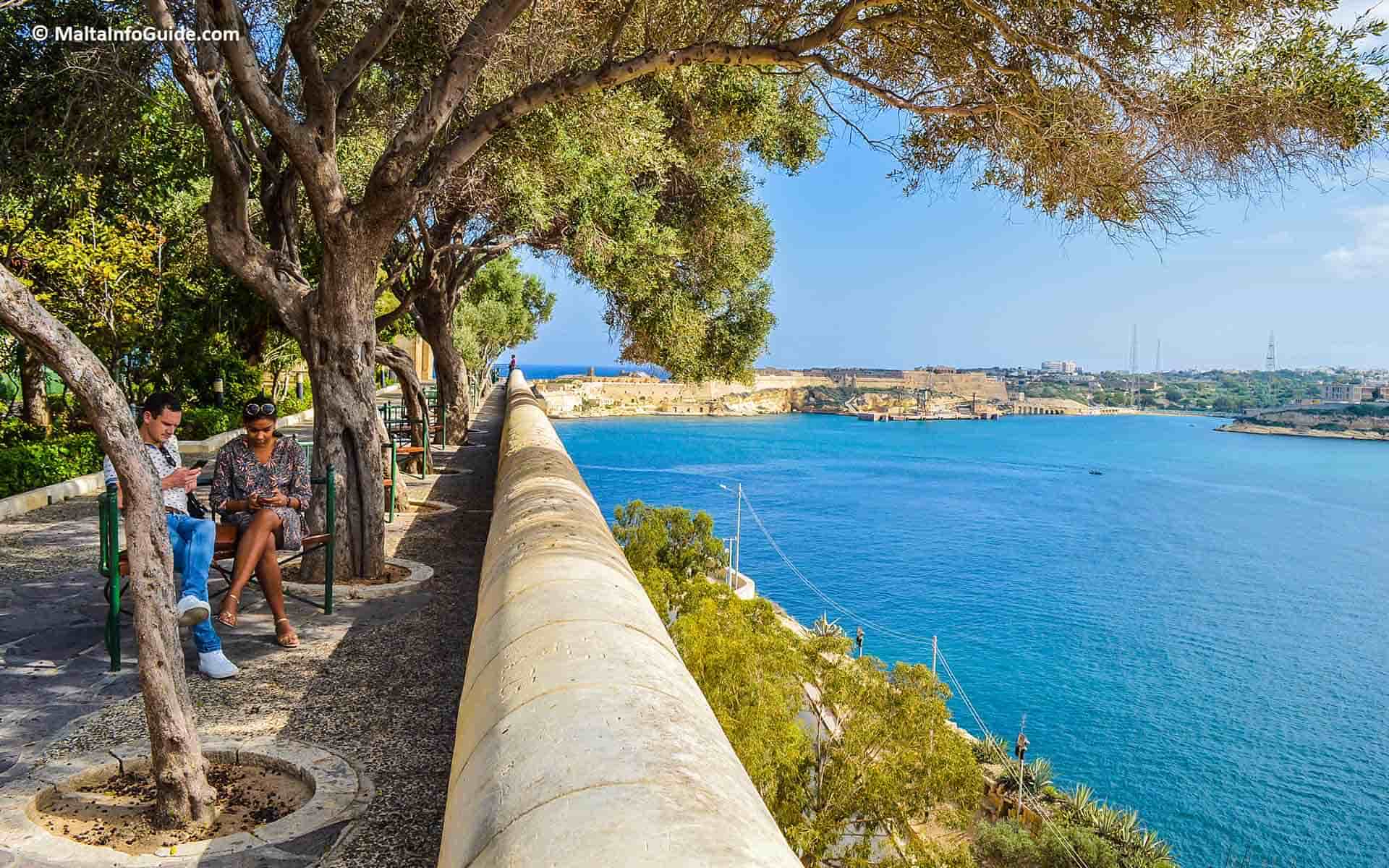 Two people sitting down on a bench at Lower Barrakka gardens. Two people sitting down on a bench at Lower Barrakka gardens.