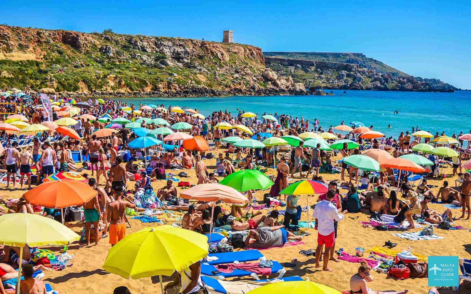 Golden Bay Malta packed with people enjoying their time at the beach.