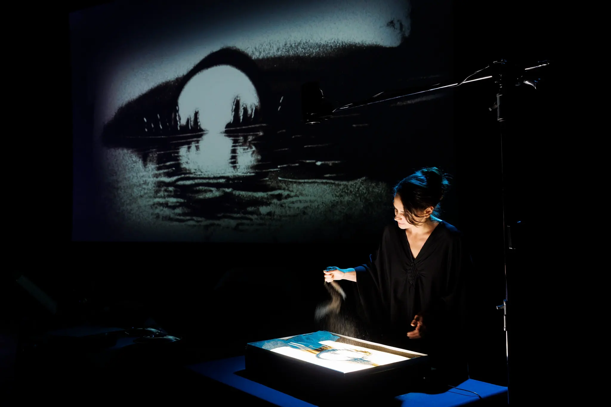Artist creating live sand art at Malta International Arts Festival.