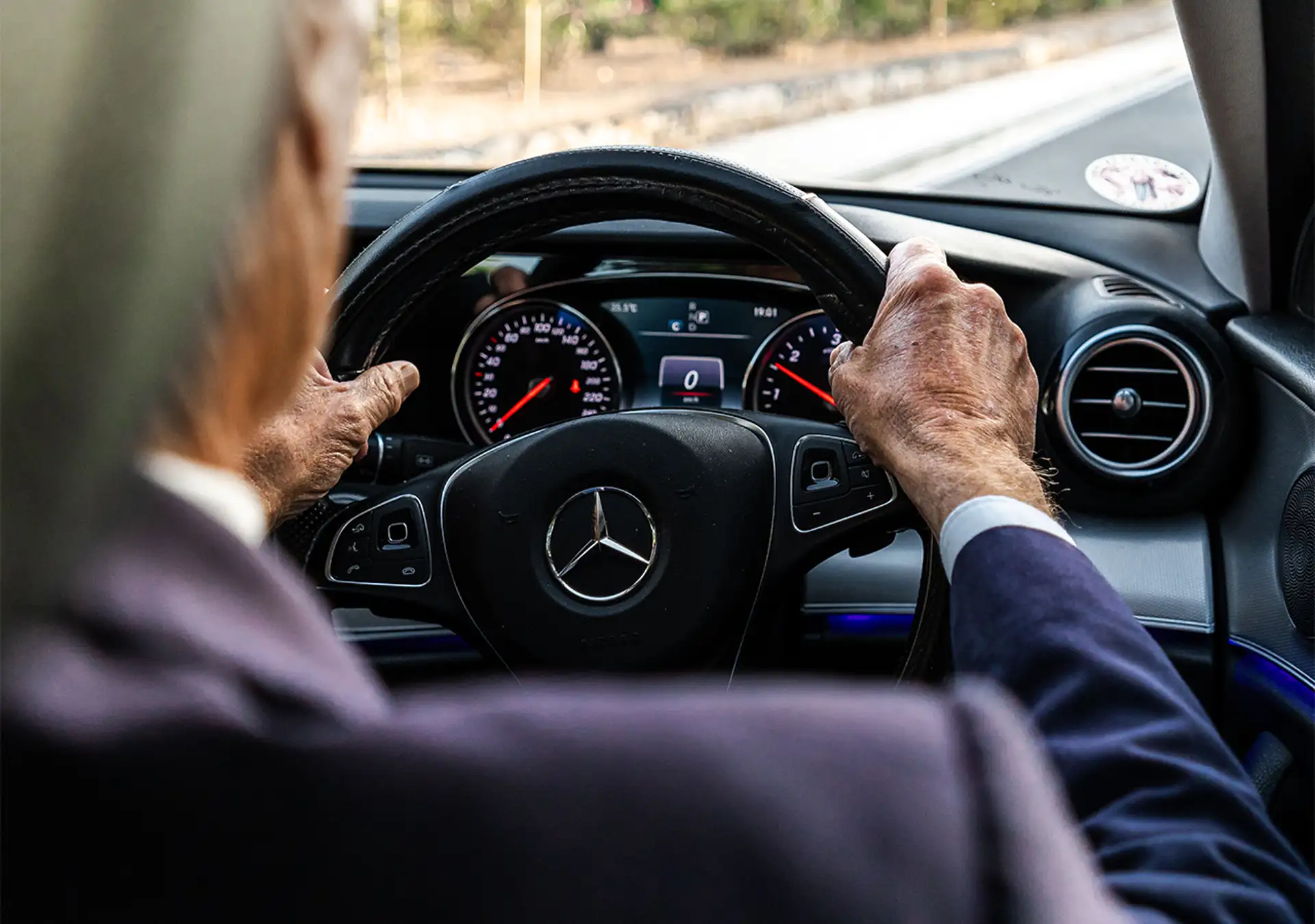 Private transfer driver behind steering wheel inside luxury vehicle Malta.