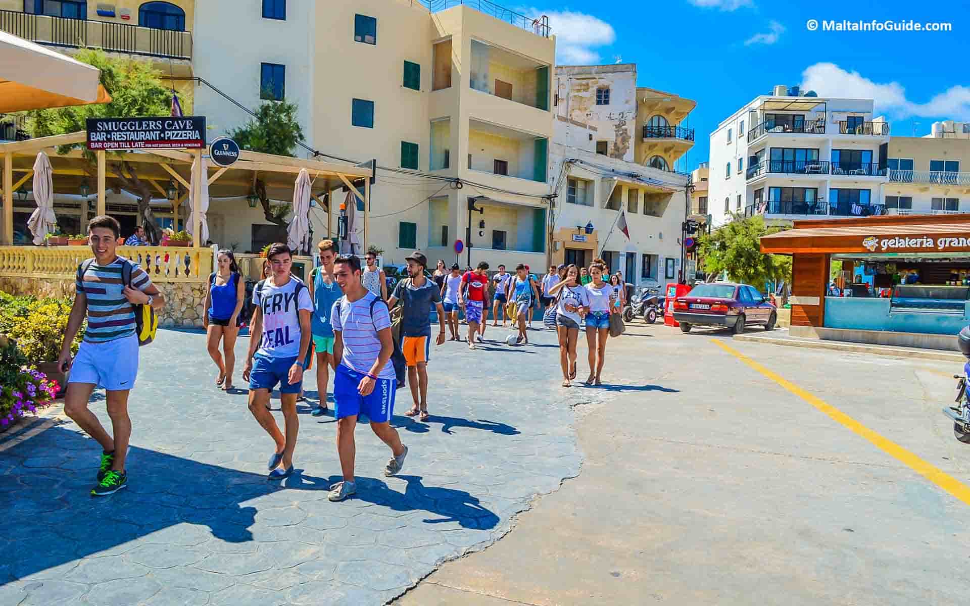Youths walking through Marsalforn Gozo village.