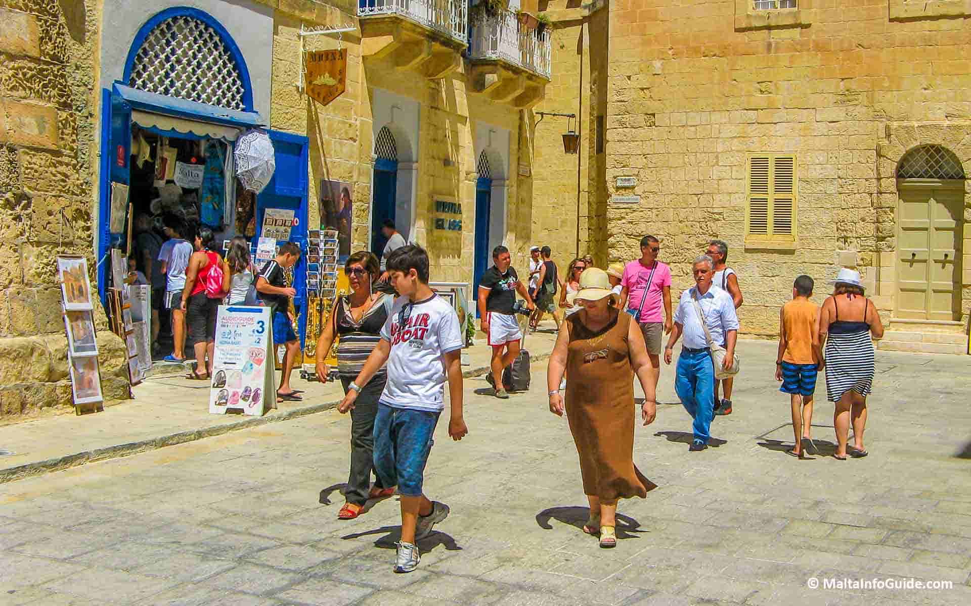 People walking by the Mdina glass shop.