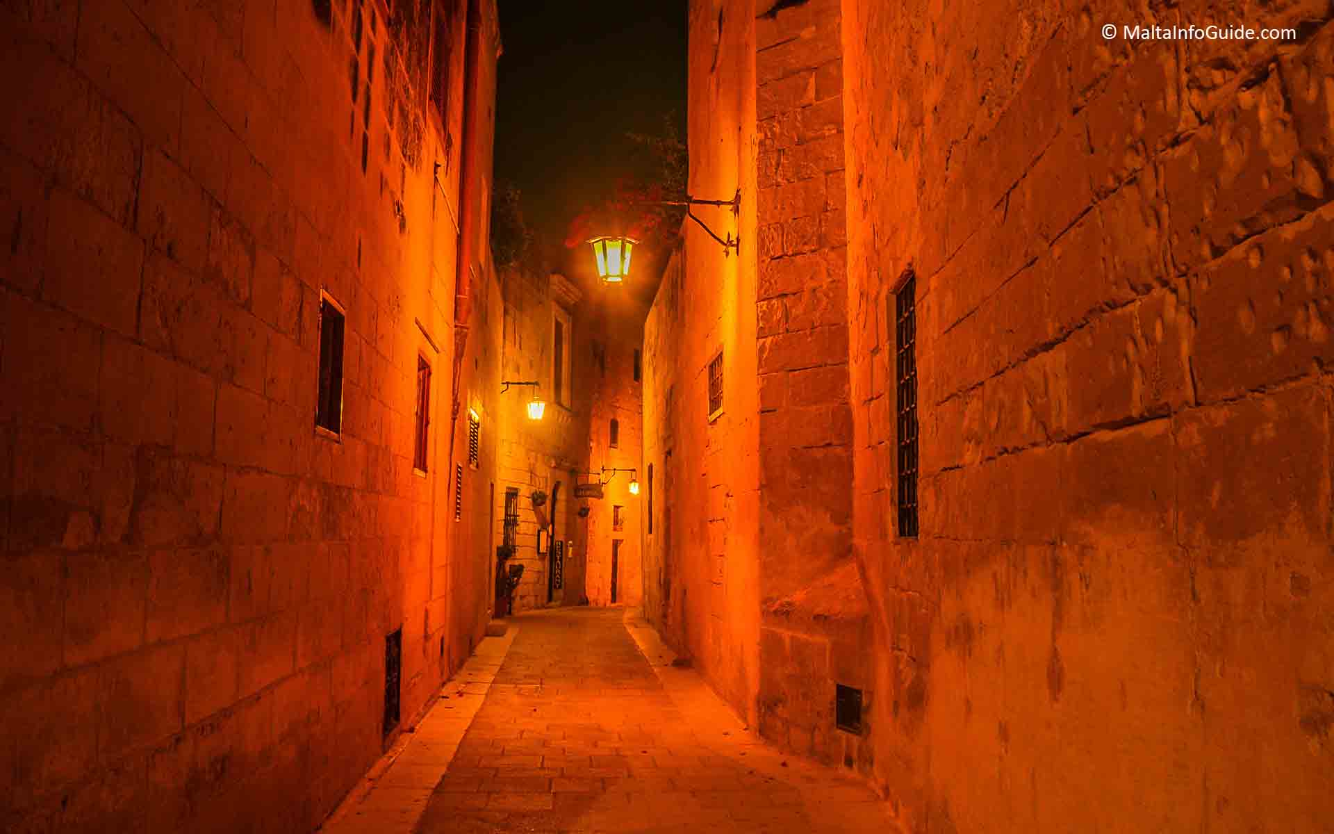 One of Mdina's narrow streets lit up at night.