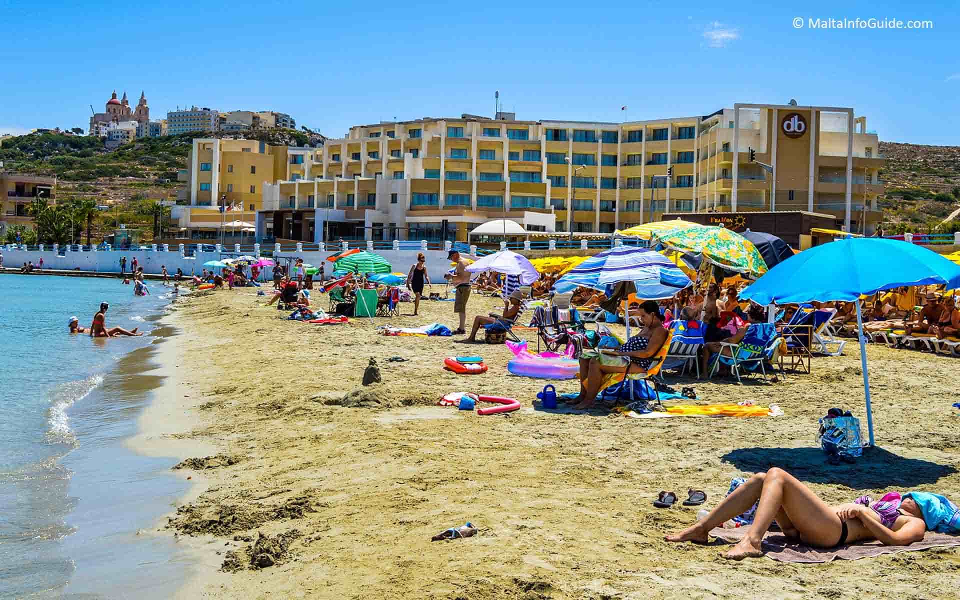 People sunbathing on the first bay of Mellieha beach Malta