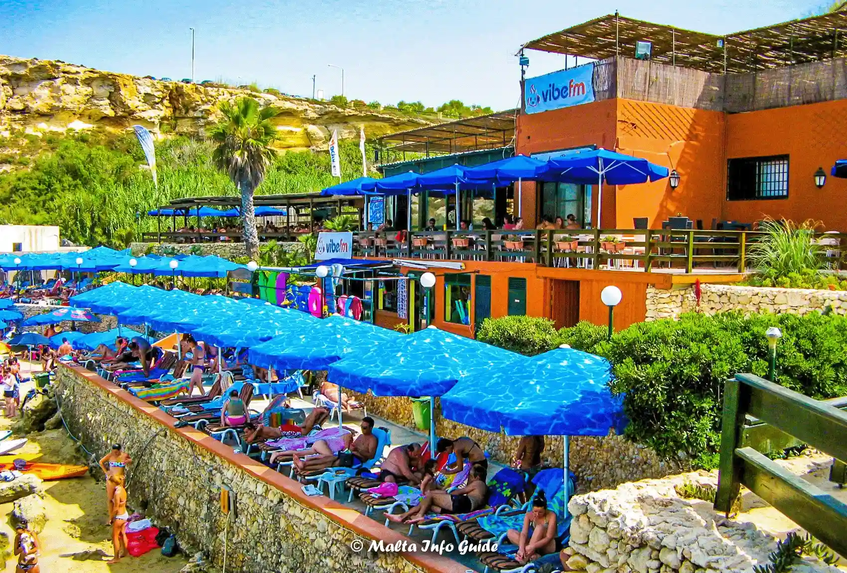 Sunbeds and blue umbrellas fill Paradise Bay Lido terraces.