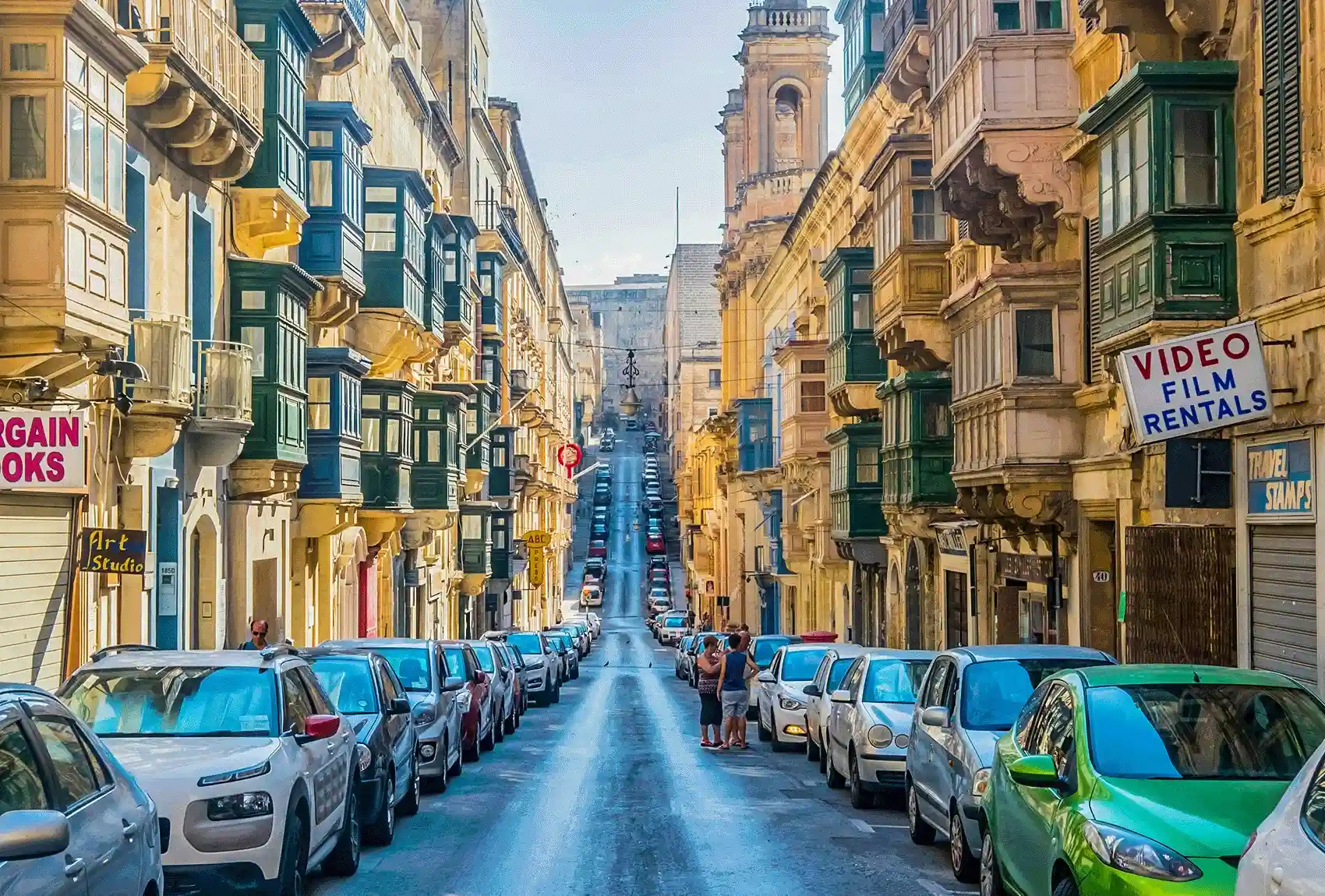Parked cars line a narrow street in Valletta.