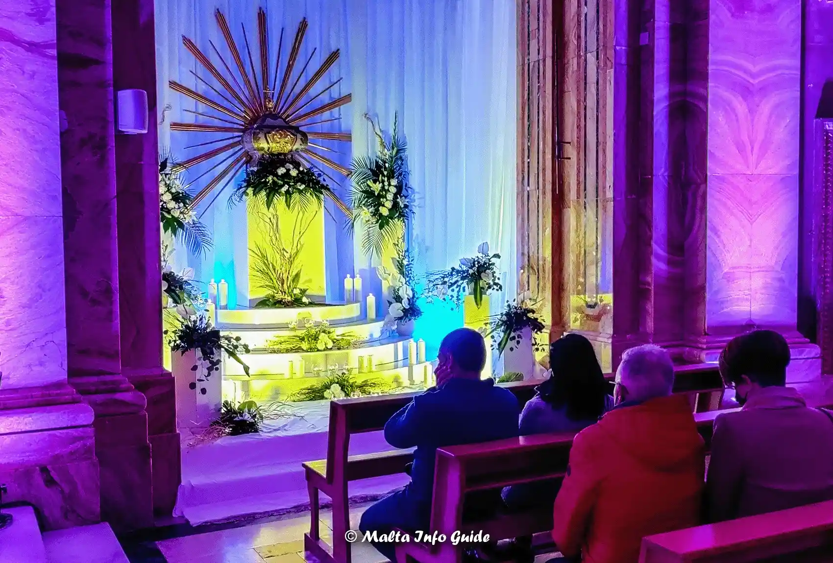 The Sepulcher in a church in Gozo during Maundy Thursday. People doing their seven visits. People doing their seven visits while sitting on benches in front of the sepulcher.