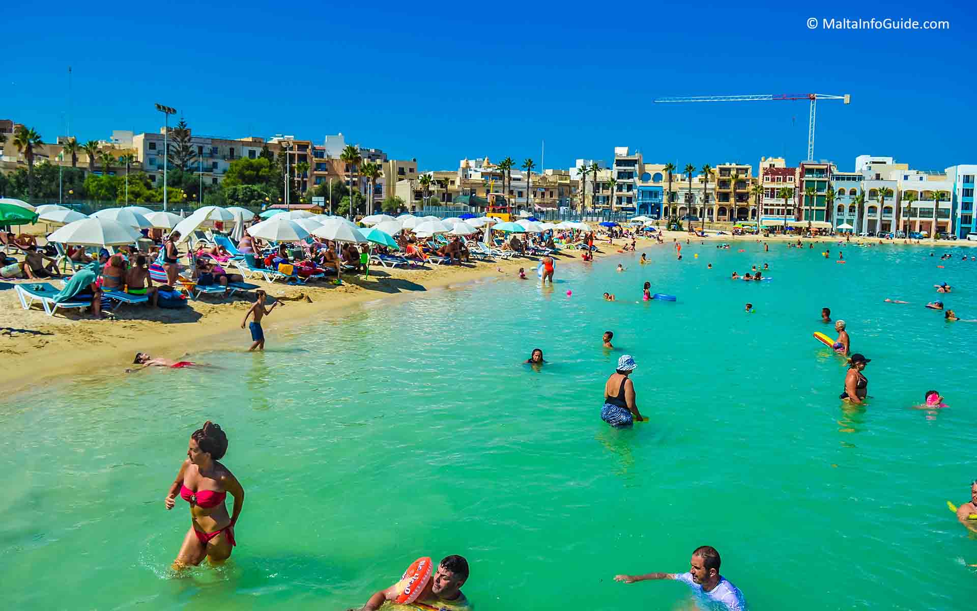 People swimming and sunbathing at Pretty Bay Malta.