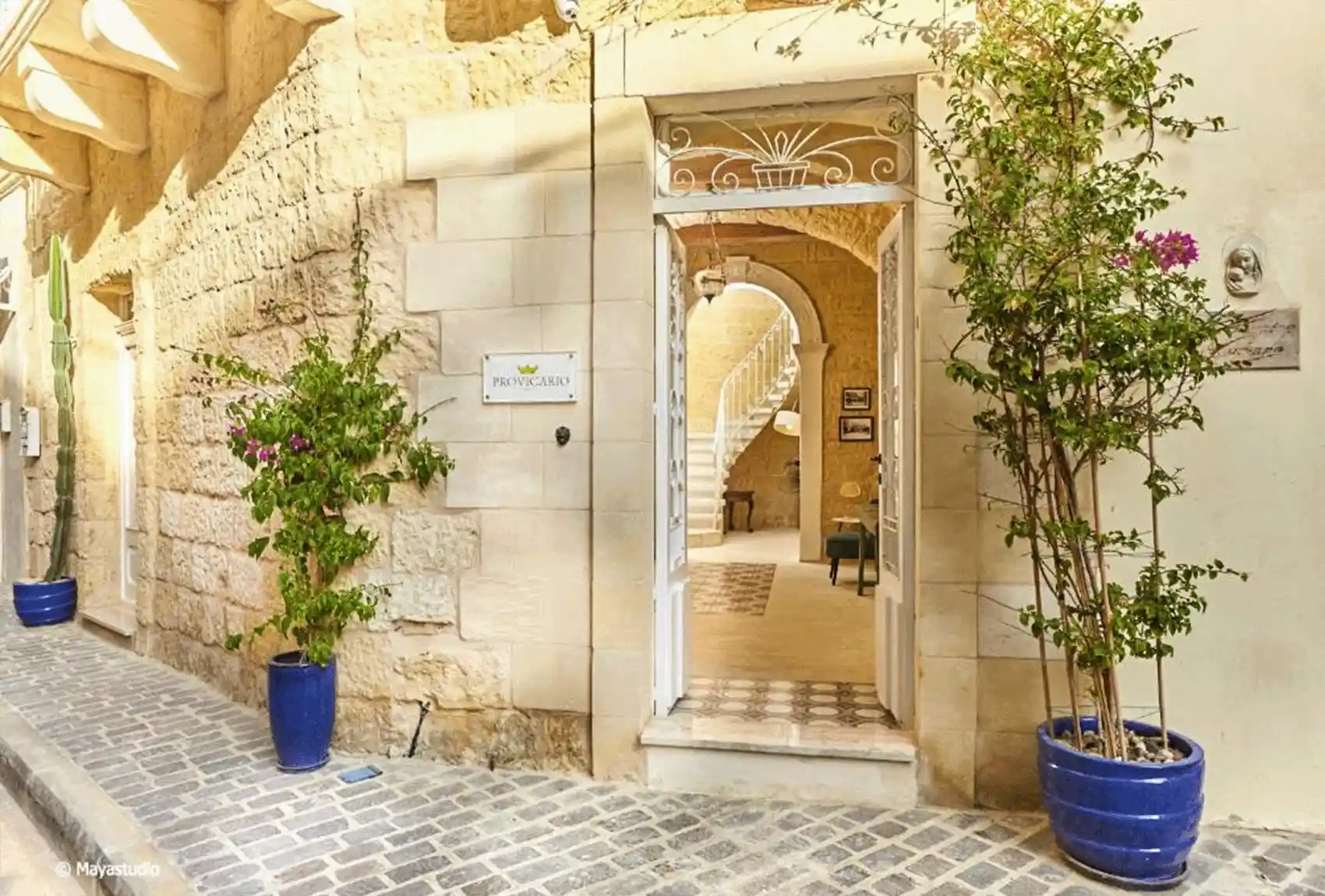 Provicario B&B Victoria Gozo, Malta, townhouse entrance with arched hallway and traditional spiral staircase.