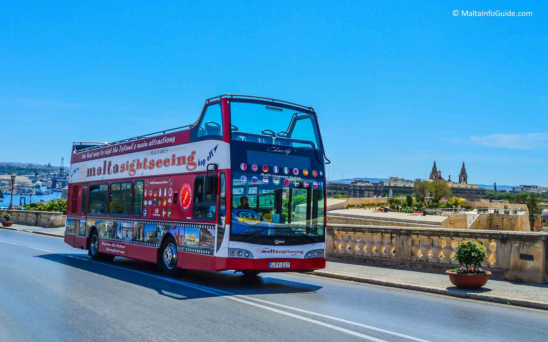 A sightseeing tour bus driving up to Valletta.