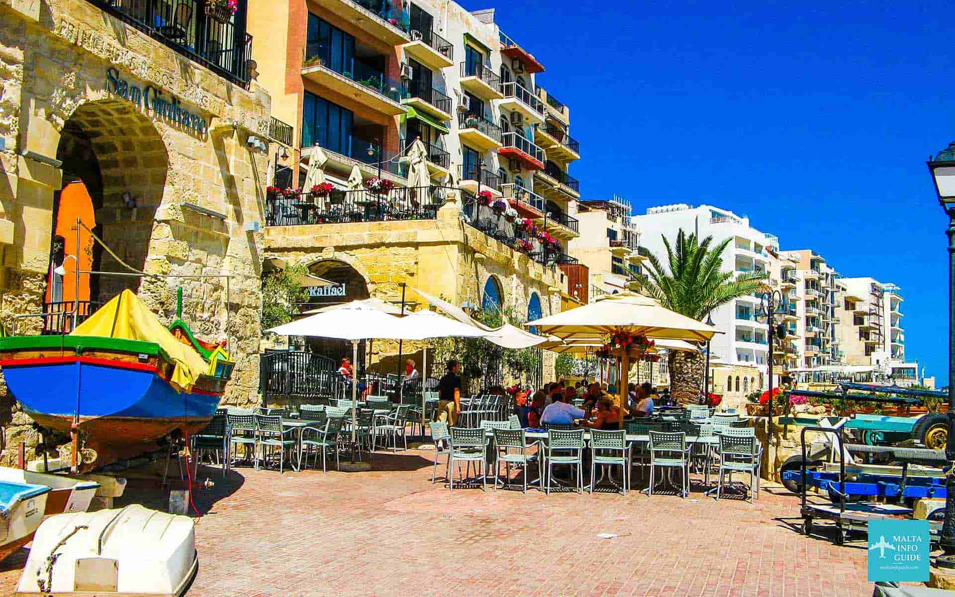 People eating lunch at a restaurant at St. Julian's Bay Malta.