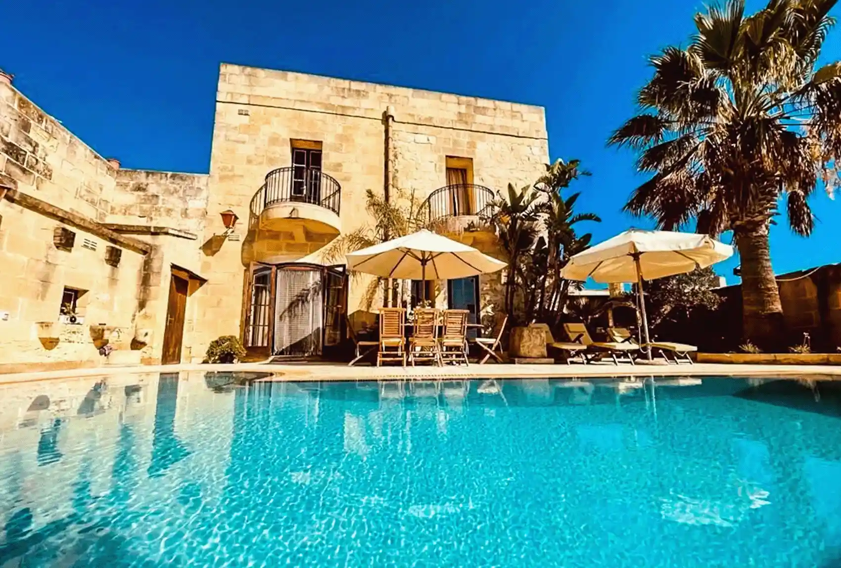 Tal-Bjar Villa/Farmhouse, San Lawrenz, Gozo, Malta: private pool, loungers, parasols, limestone courtyard.