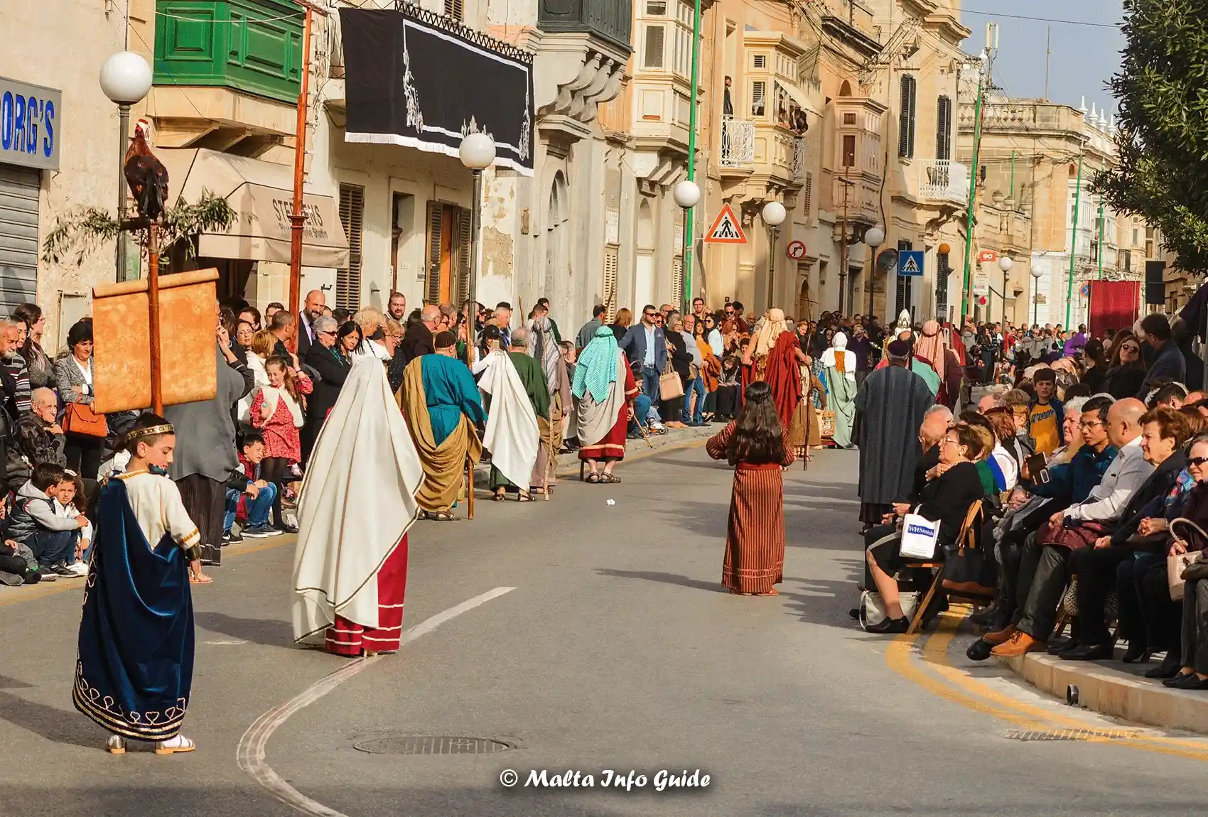 People walking the street for the Good Friday processions, while people watching. The Good Friday Processions in Zejtun Malta.