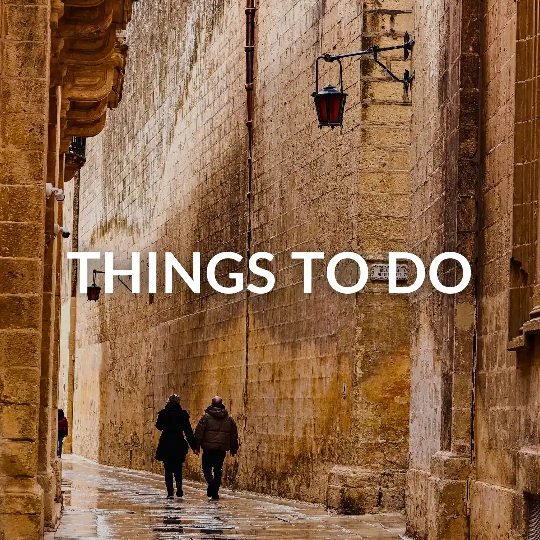 A couple walking through Mdina streets after a rain storm.