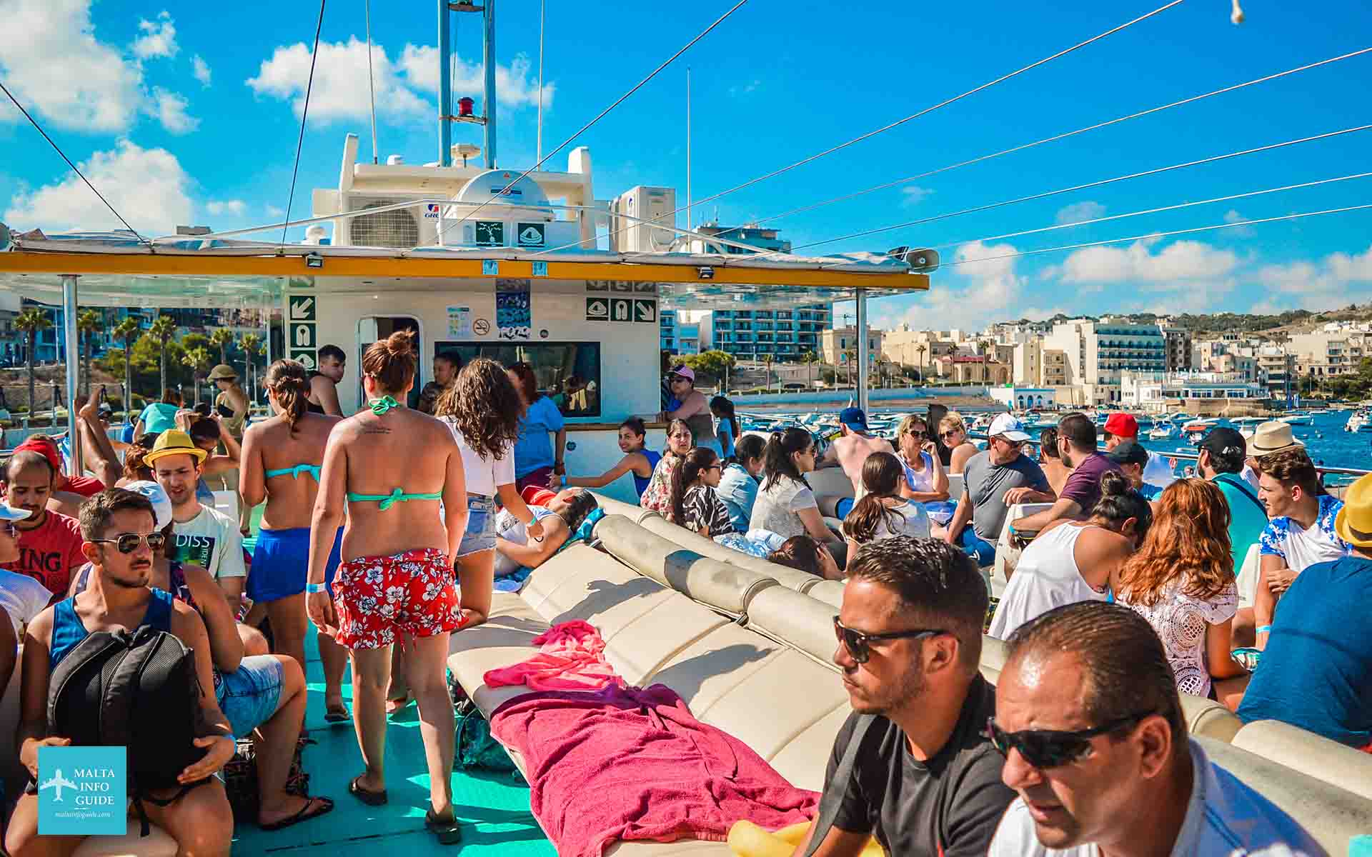 Passagers assis sur le pont supérieur du catamaran en route vers Blue Lagoon Comino.