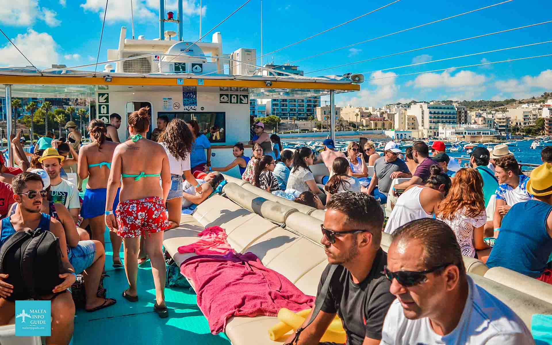 Passeggeri seduti sul ponte superiore del catamarano diretti a Blue Lagoon Comino