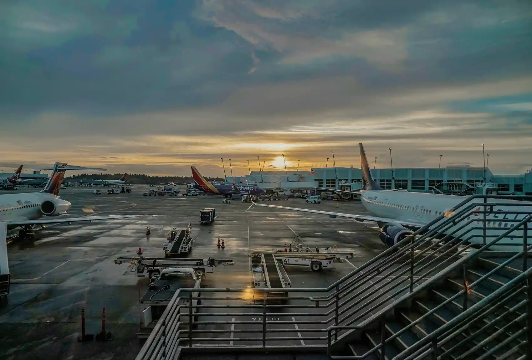 Commercial aircraft parked at an airport terminal at sunset