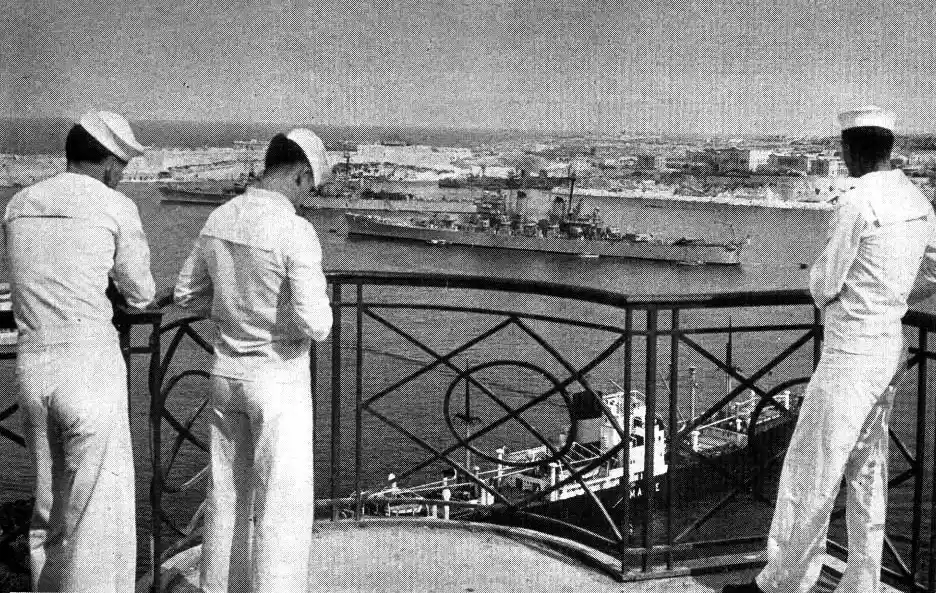 Sailors watching naval ships at the Grand Harbour, Valletta, Malta.