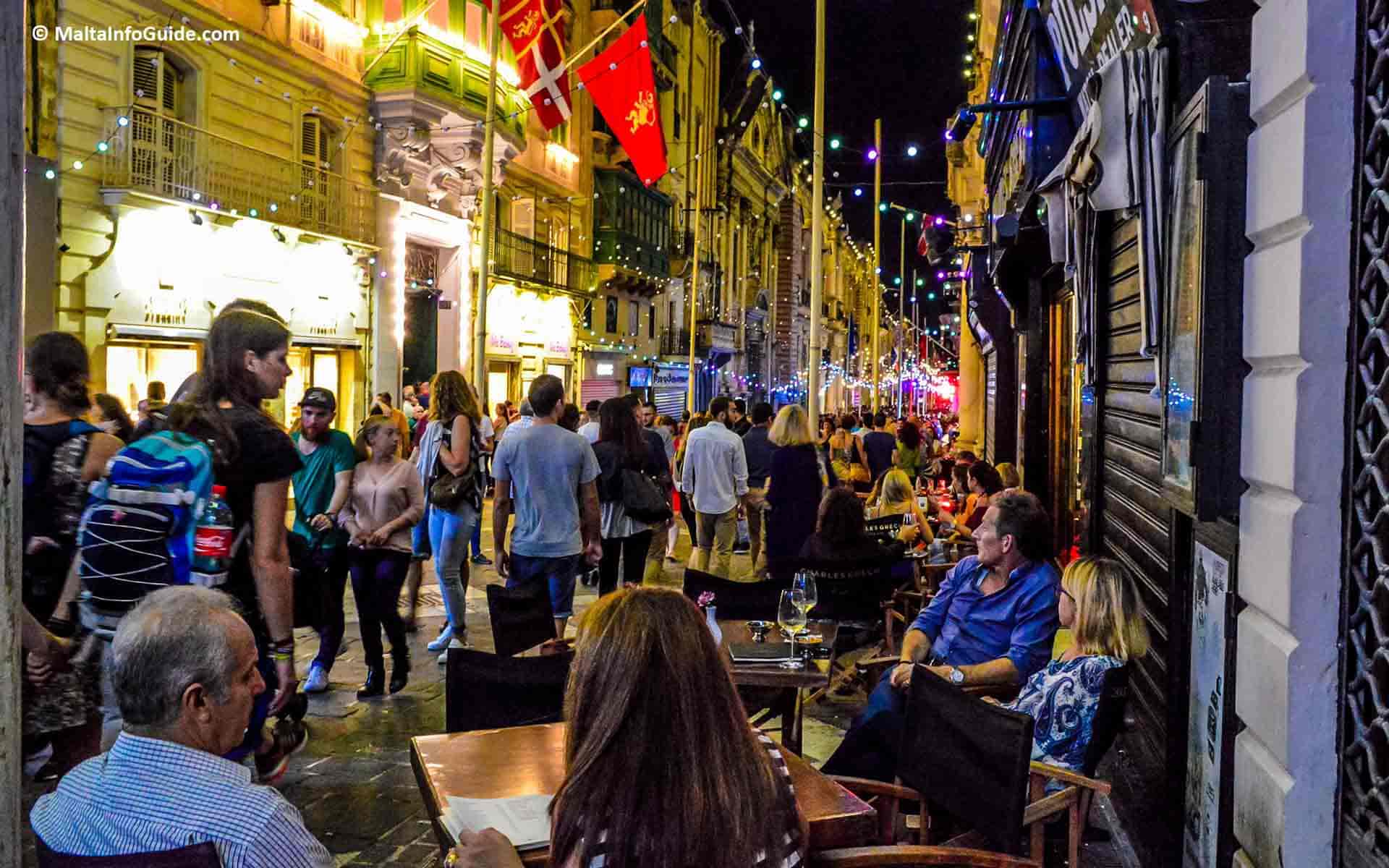 People dining and having a drink at a bar in Valletta.