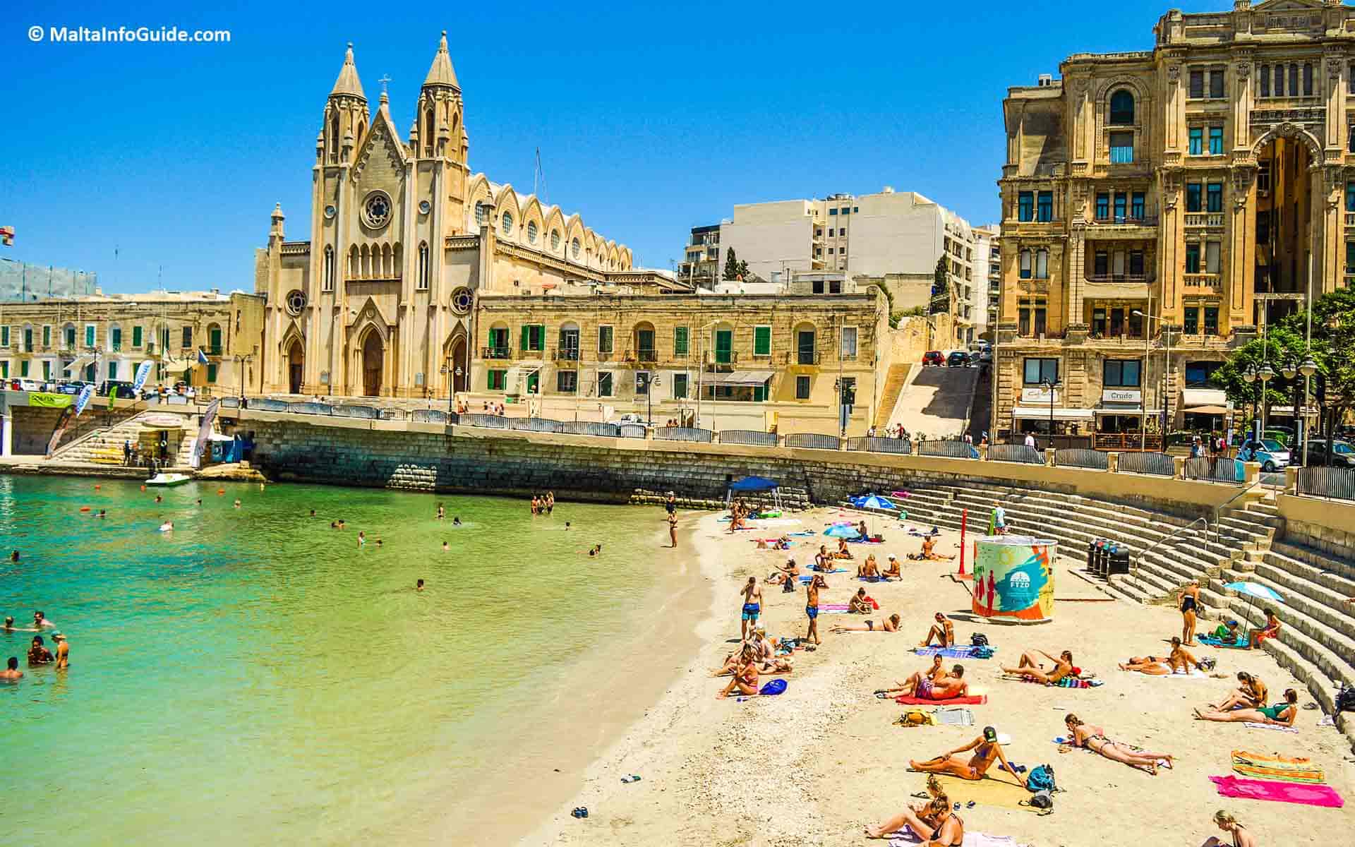 People sunbathing at Balluta bay Malta.