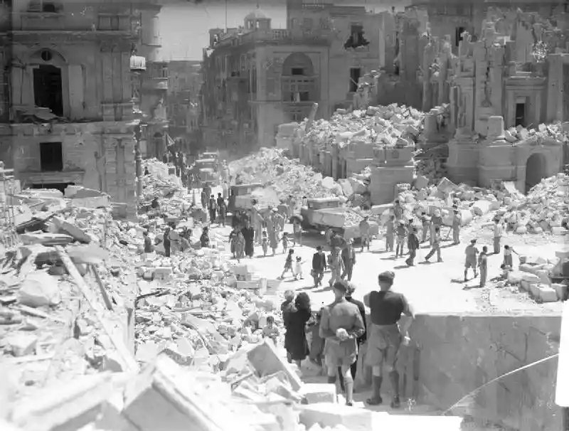 The local population walking in Valletta around the damaged World War II buildings.